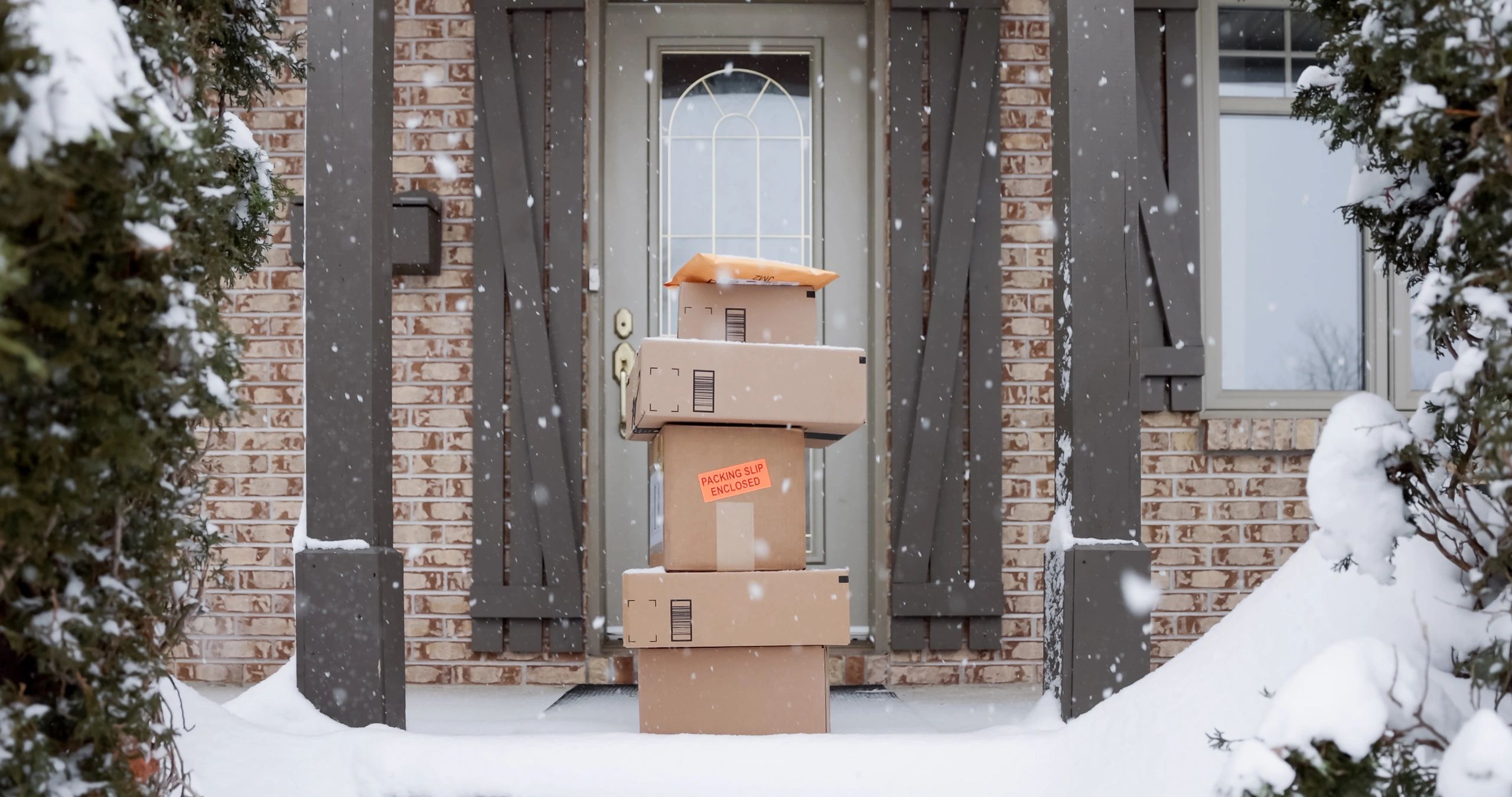 Delivered parcels outside a door in winter, representing delivery conditions and documentation.